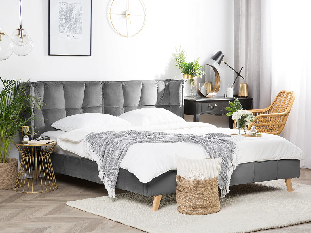 Modern bedroom with gray upholstered bed, white bedding, and decorative elements.