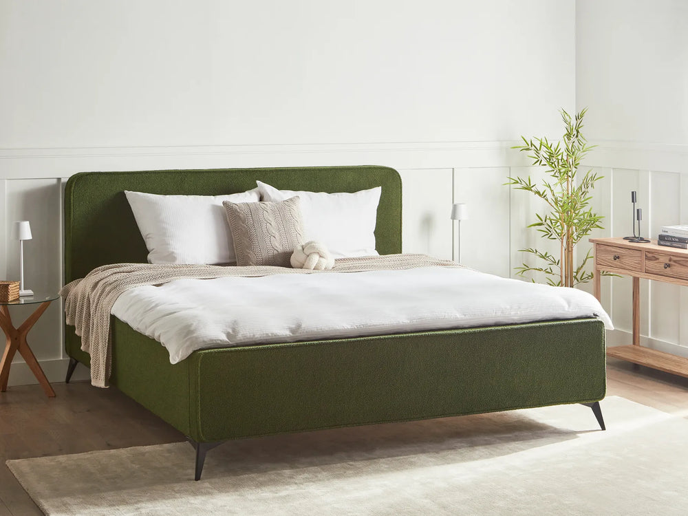 Green bed with white bedding in a bedroom setting