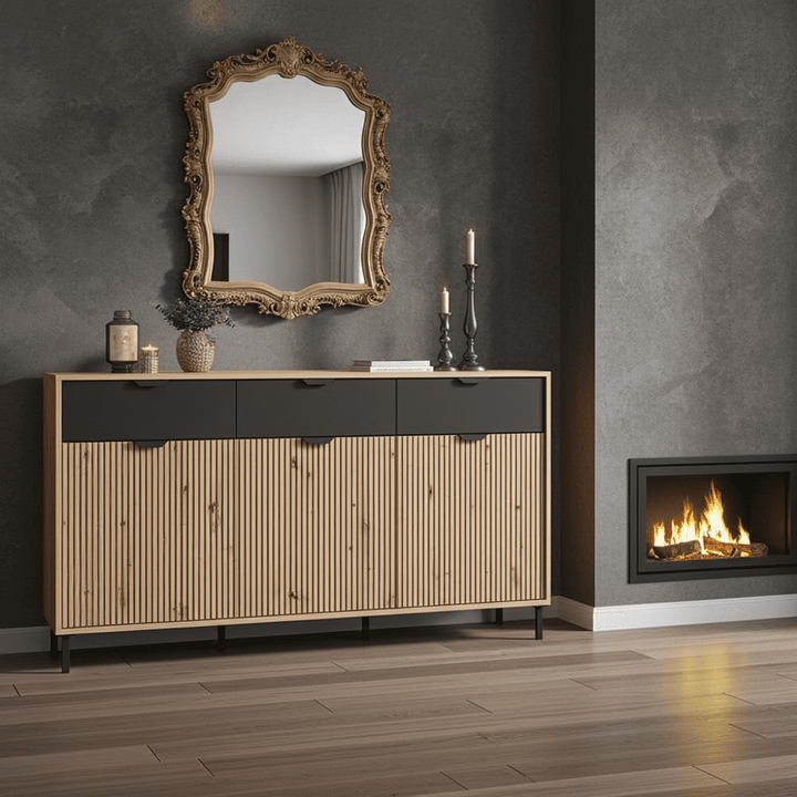 Wooden sideboard with decorative mirror and candles in a room with a fireplace.