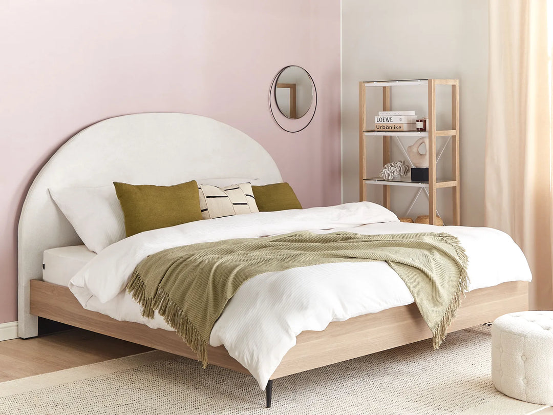 Bedroom with a bed featuring white bedding and green throw blanket against a pink wall.