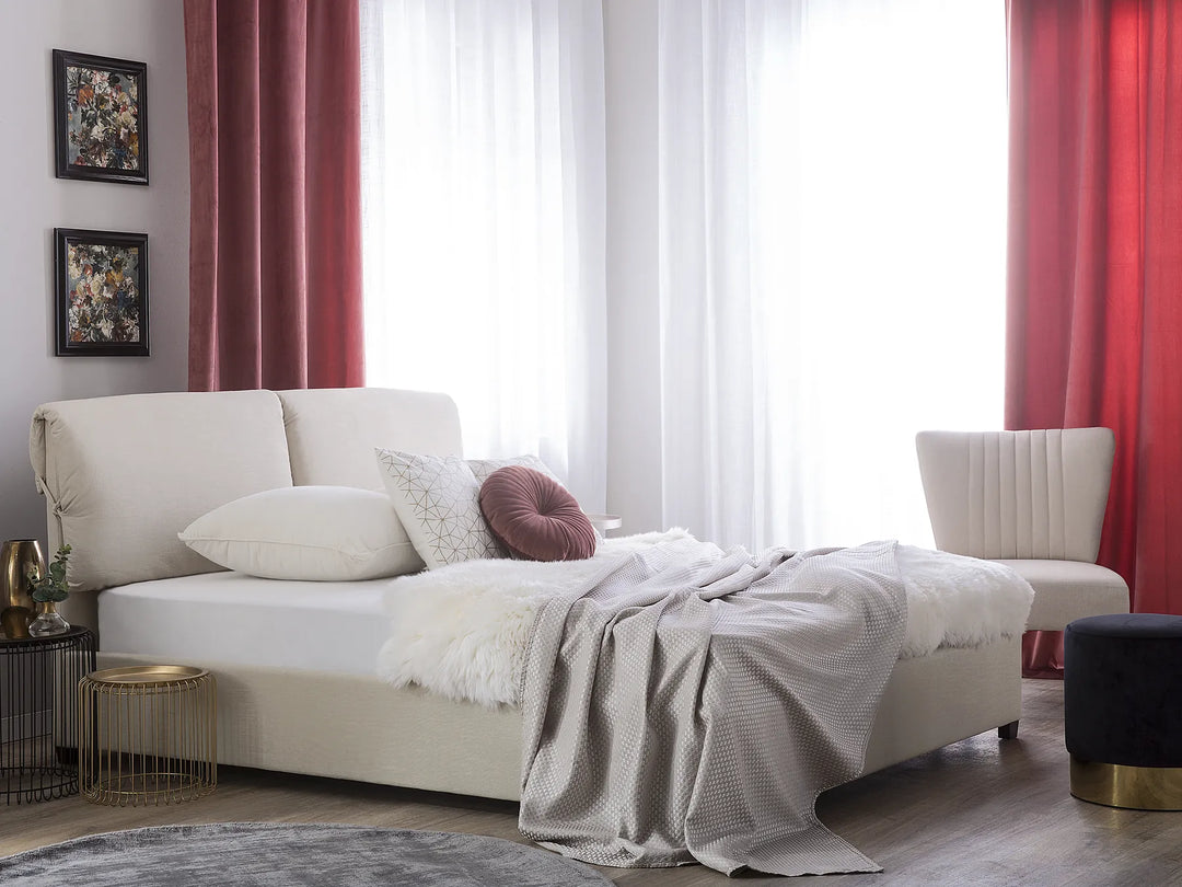 Modern living room with a white sofa, red curtains, and decorative pillows.