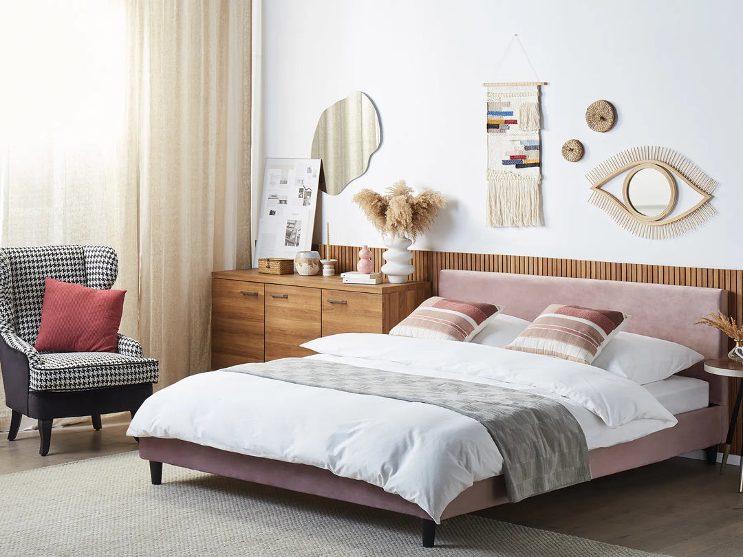 Modern bedroom with a pink bed, armchair, and decorative wall art.