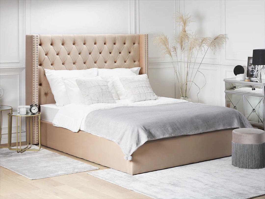 Beige upholstered bed with white bedding in a bedroom setting.