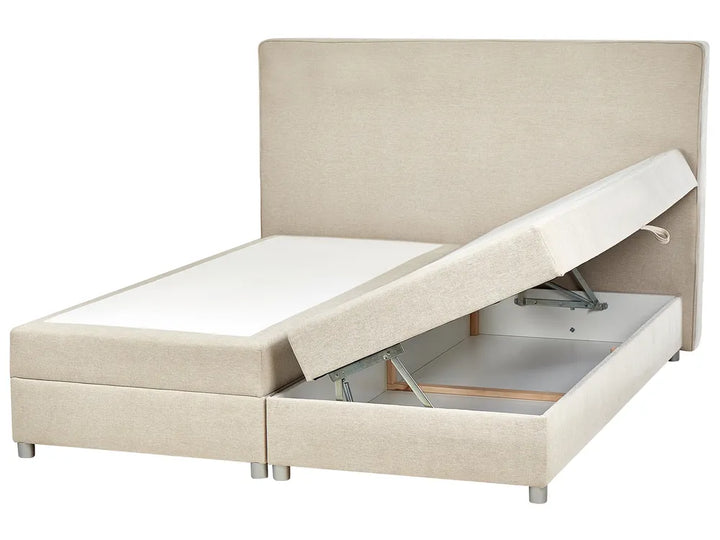 Beige upholstered bed with storage compartment on a white background