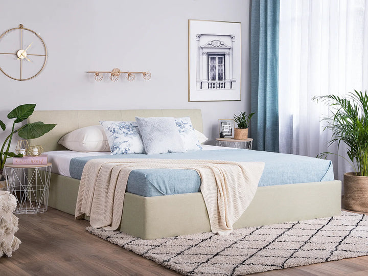 Neatly made bed with decorative pillows and a blanket in a well-lit bedroom.