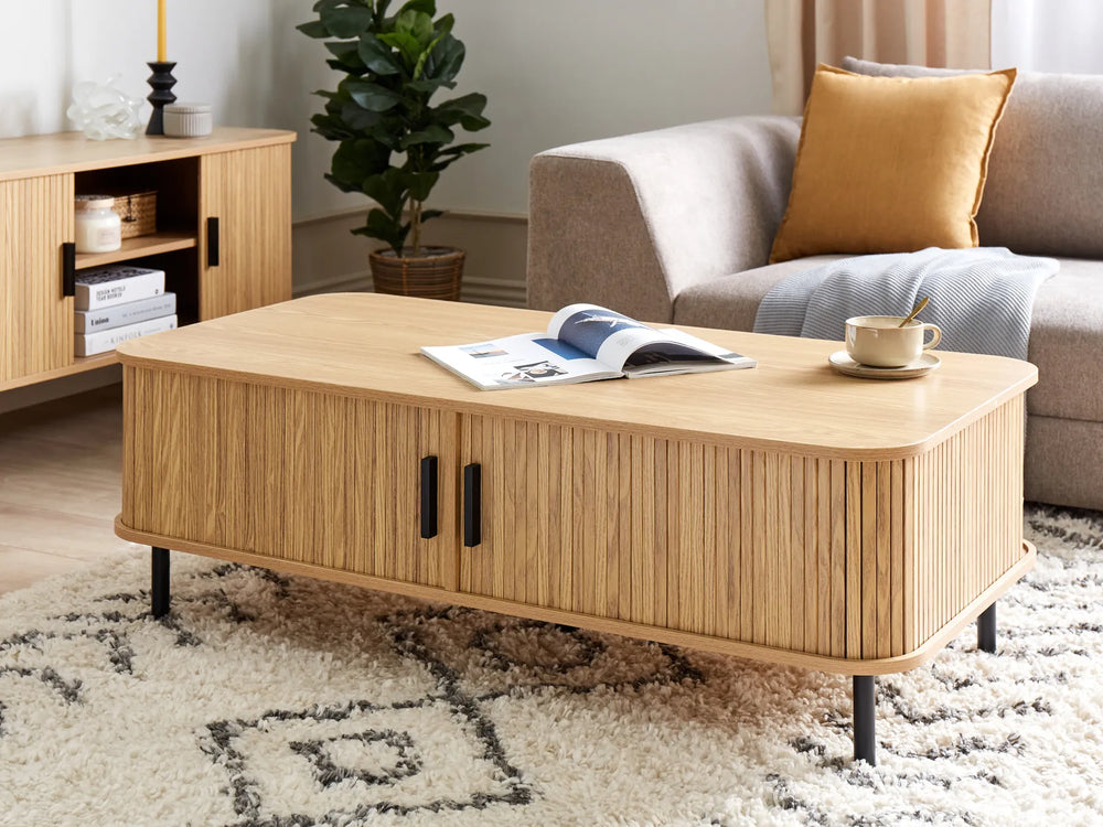 Wooden coffee table in a living room with a magazine and cup on top