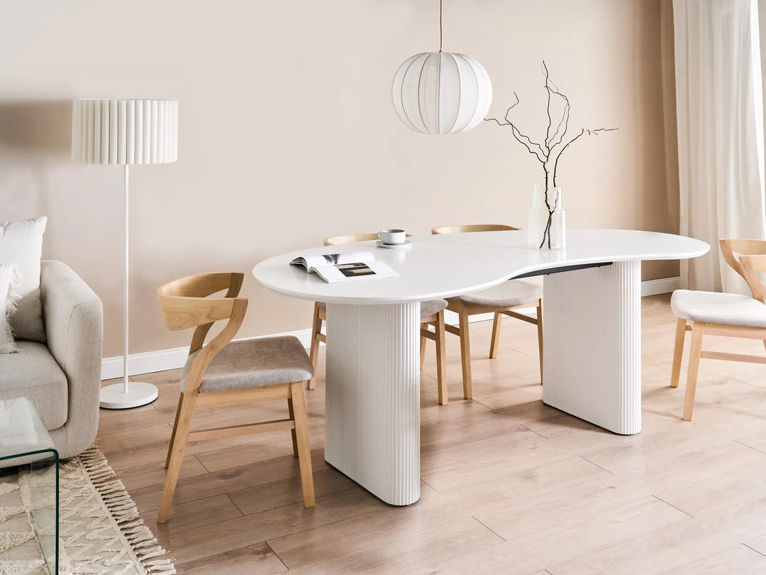 Modern dining room with a white oval table and wooden chairs.