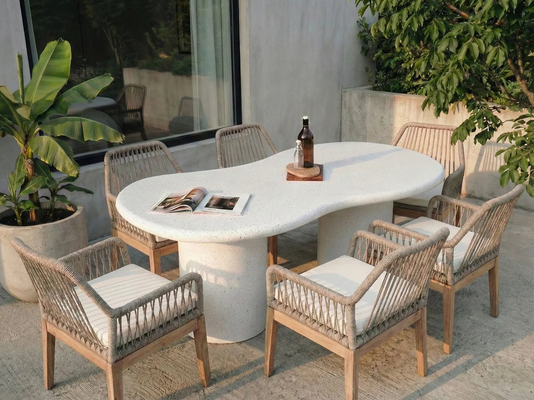 Outdoor dining area with a round table and chairs on a patio.