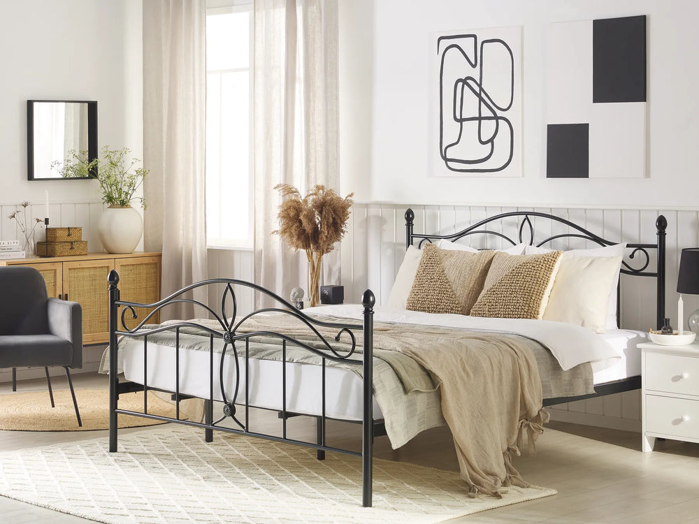 Bedroom with a black metal bed frame, white bedding, and decorative pillows.