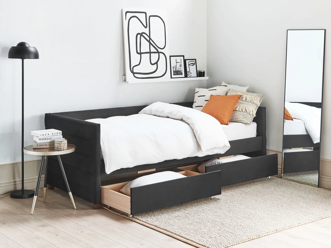 Black bed frame with storage drawers in a bedroom setting.