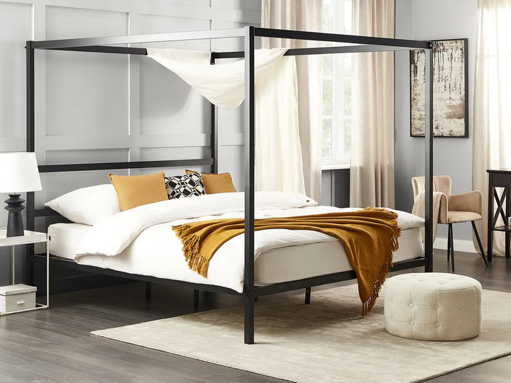 Bedroom with a black metal canopy bed, white bedding, and yellow blanket.