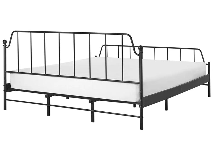 Black metal bed frame with white mattress on a white background