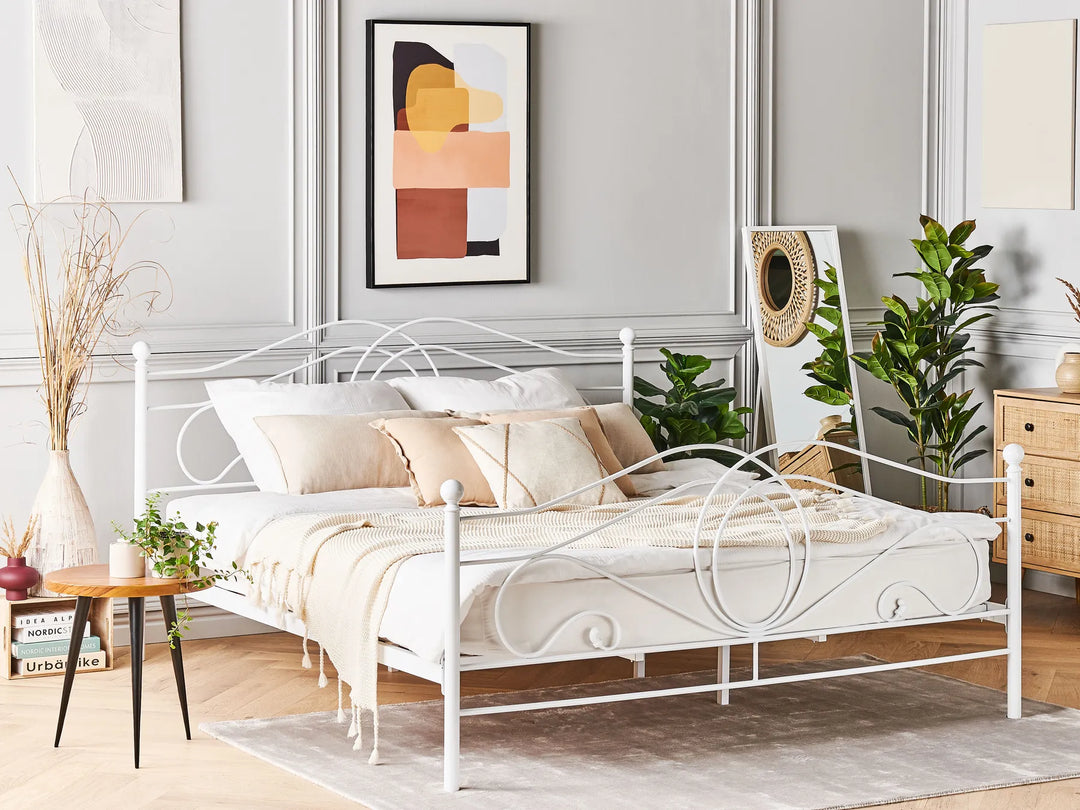 White metal bed in a bedroom with decor elements