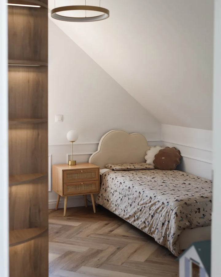 Bedroom with wooden nightstand and bed with patterned bedding.