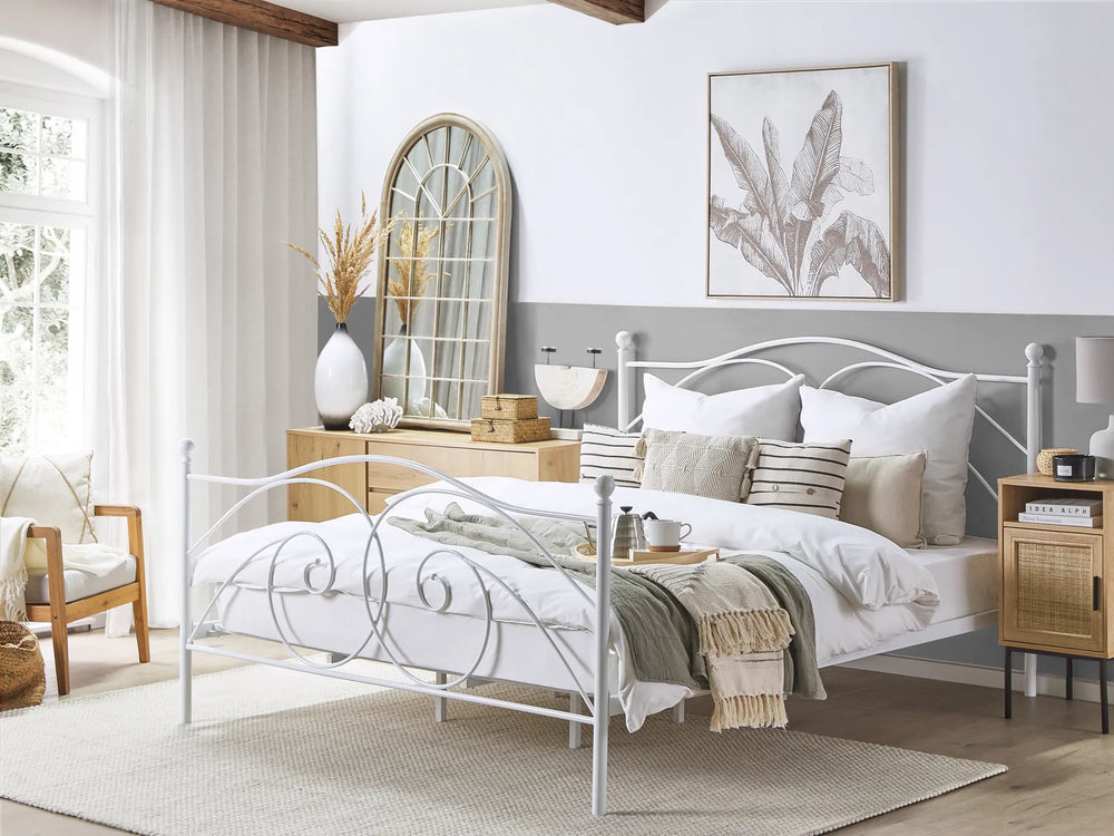 Neatly made bed in a bedroom with decorative pillows and a side table.