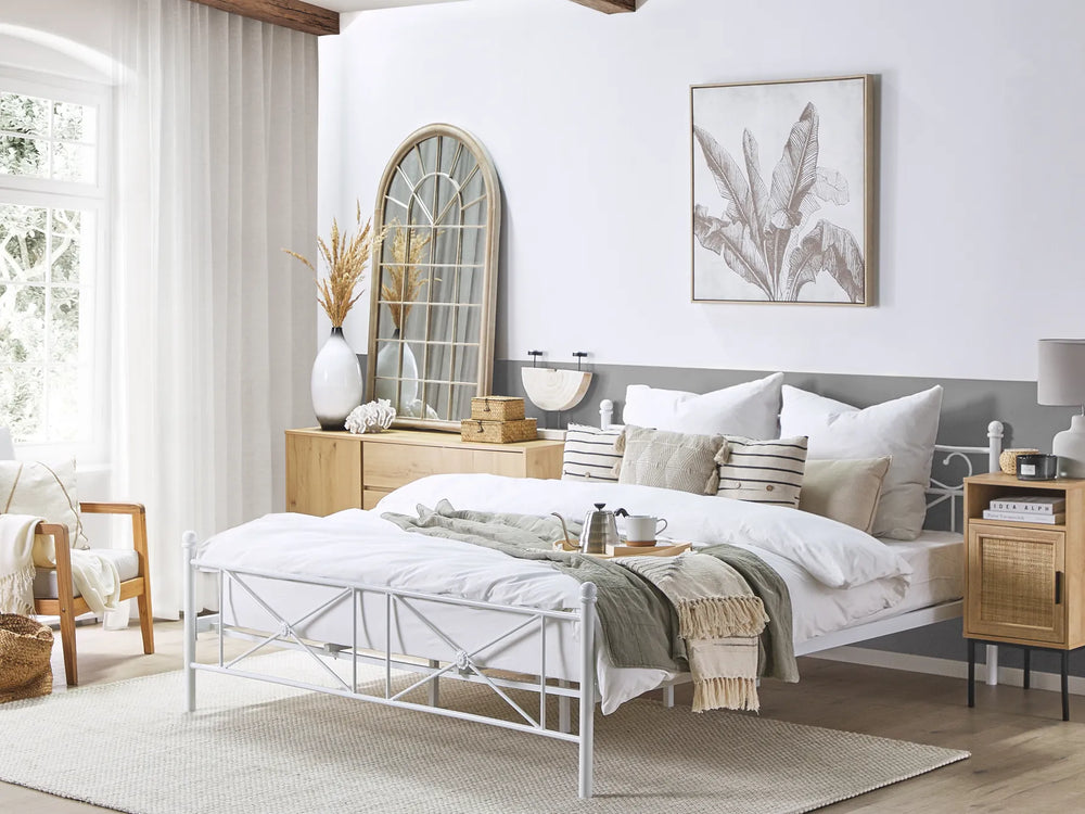 Neatly arranged bedroom with a bed, side tables, and decorative items.