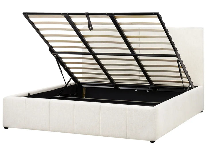White upholstered bed with a black metal frame on a white background