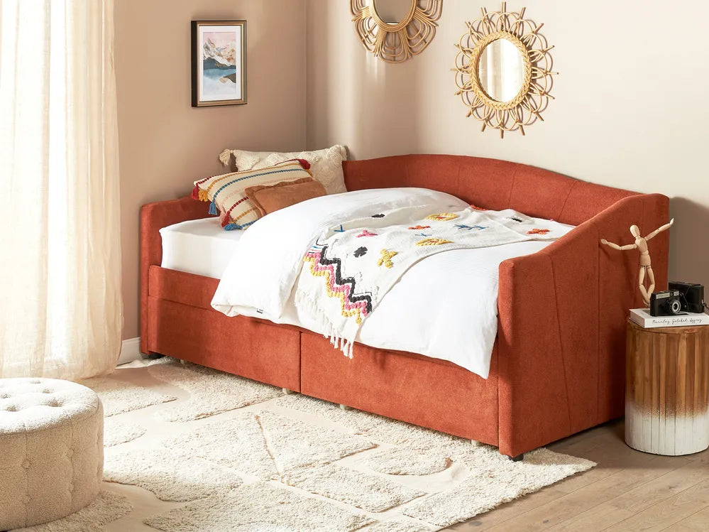 Orange upholstered bed with white bedding and colorful blanket in a room with mirrors and a rug.