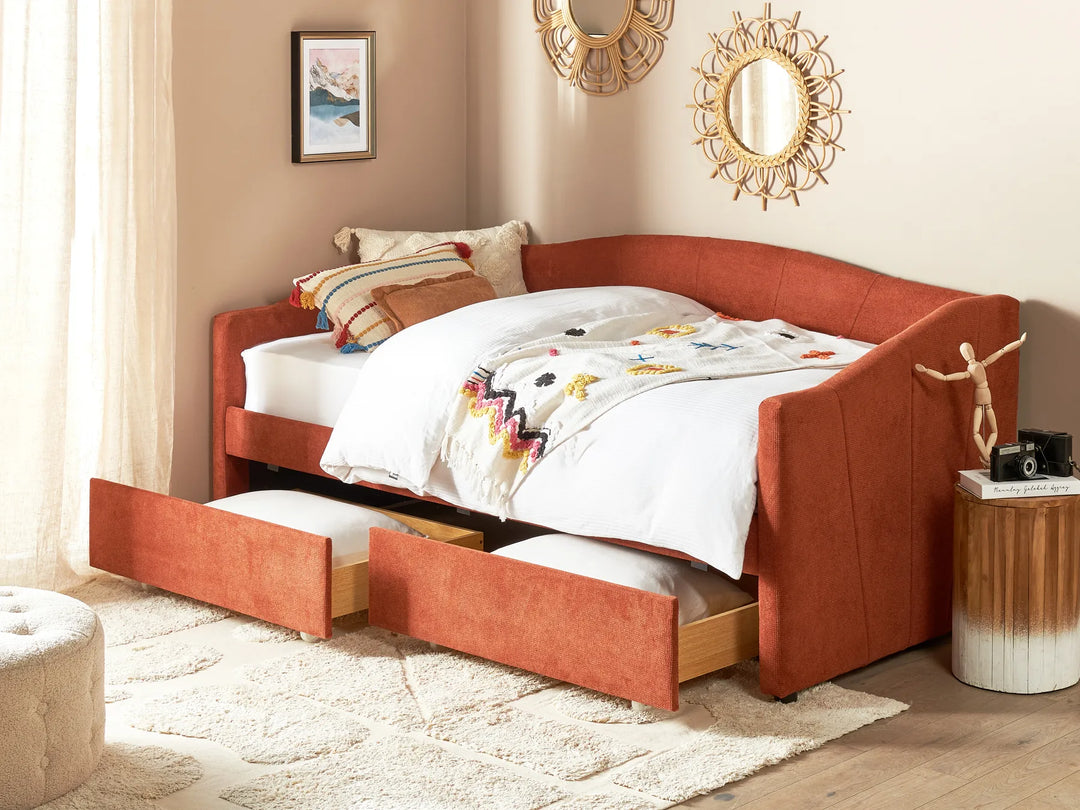 Orange upholstered bed with storage drawers in a bedroom setting.