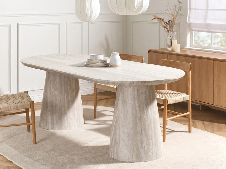 Dining room with a marble table and wooden chairs in a bright room.