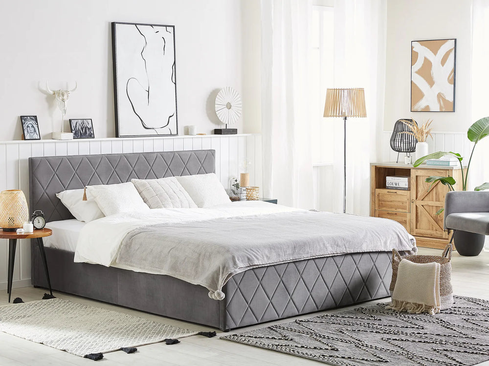 Modern bedroom with a gray upholstered bed, white bedding, and decorative elements.