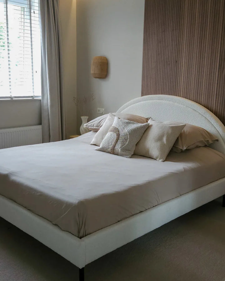 Neatly made bed with pillows in a bedroom setting