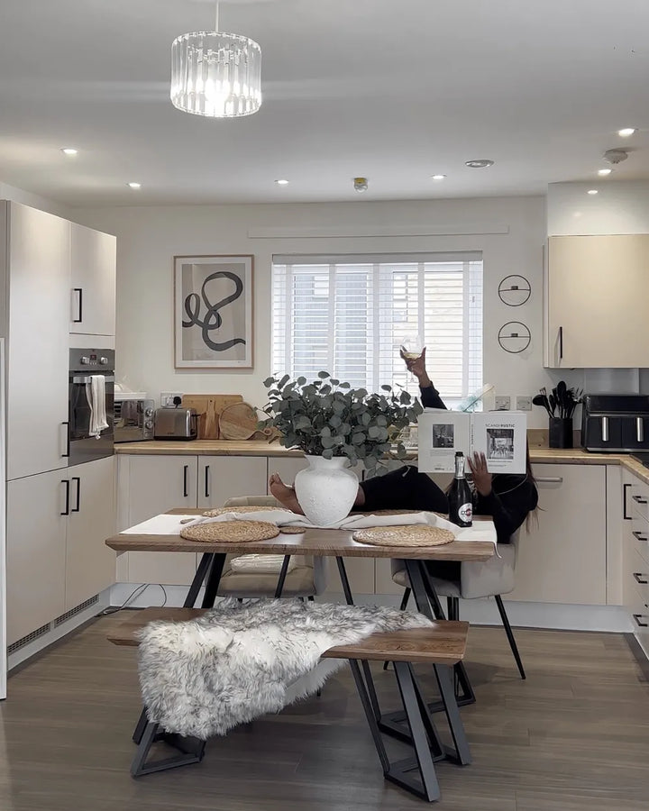 Modern kitchen with a dining area featuring a table, chairs, and decorative elements.