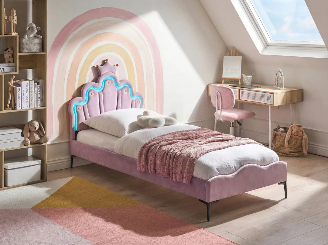 Children's bedroom with a pink bed, desk, and colorful wall design.