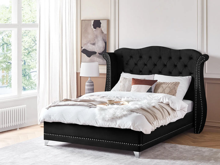 Black upholstered bed with white bedding in a bright bedroom
