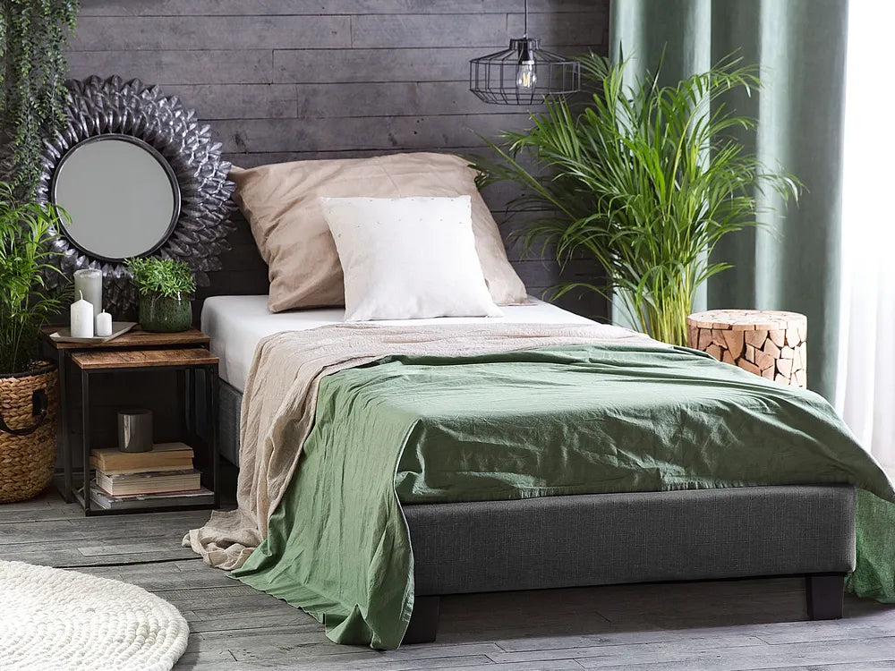 Bedroom with a bed, green blanket, and decorative elements.