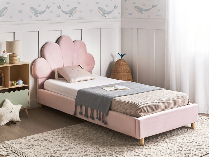 Pink children's bed in a room with whale-themed wallpaper
