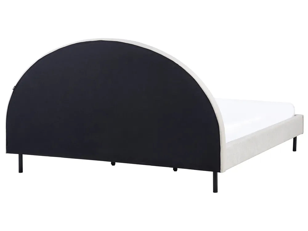 Bed with black curved headboard and white mattress on a white background