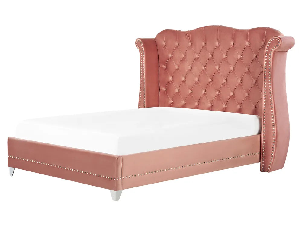 Pink upholstered bed with white mattress on a white background
