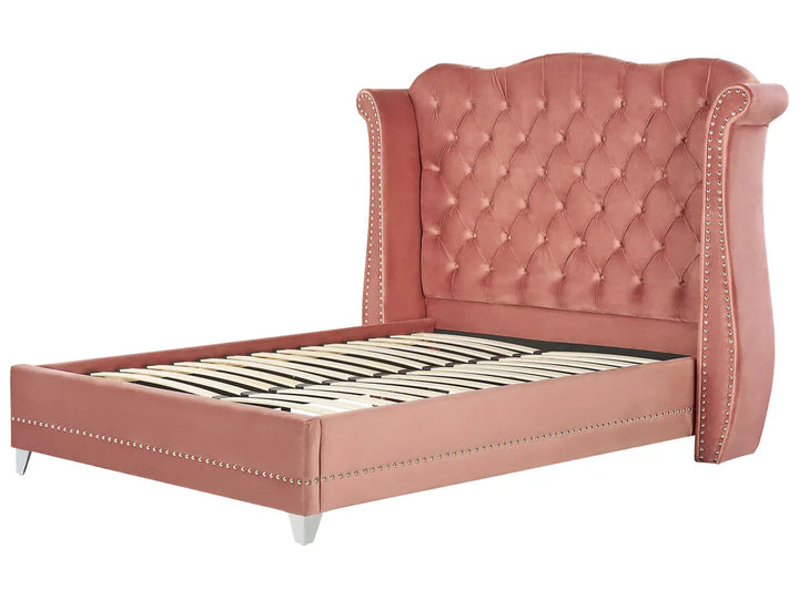 Pink upholstered bed with tufted headboard on a white background
