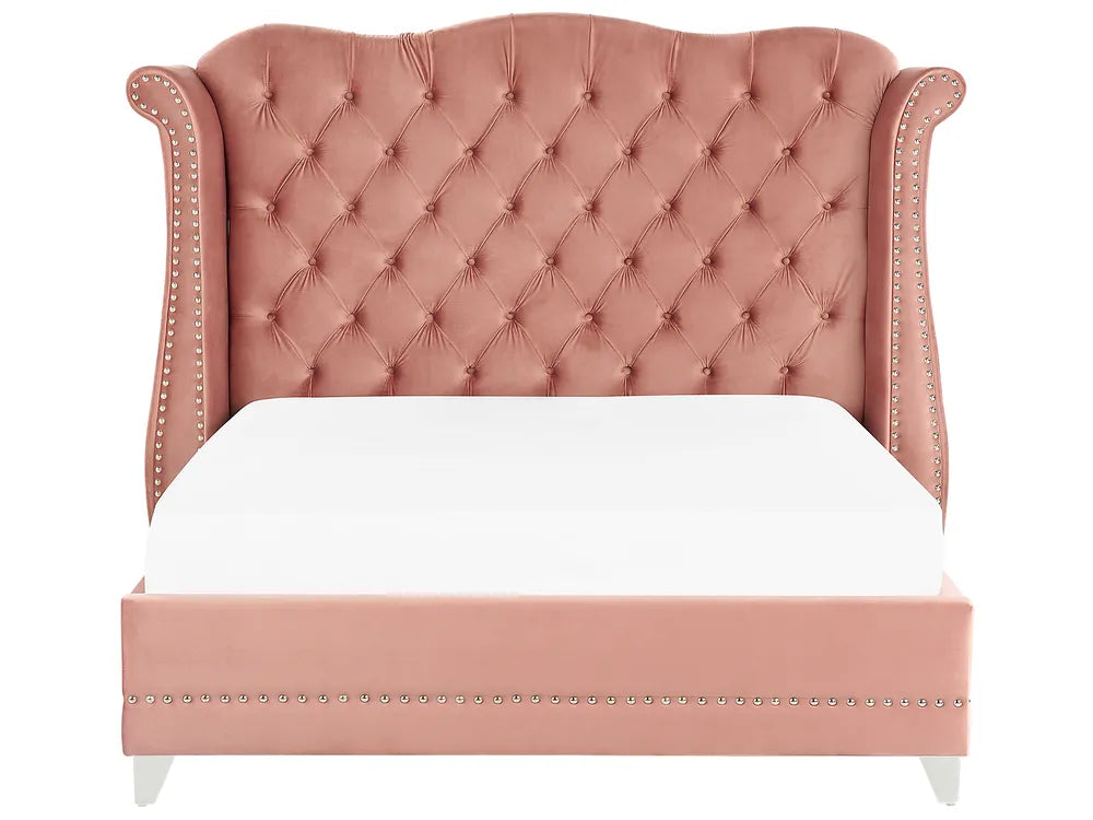 Pink tufted bed with white bedding on a white background