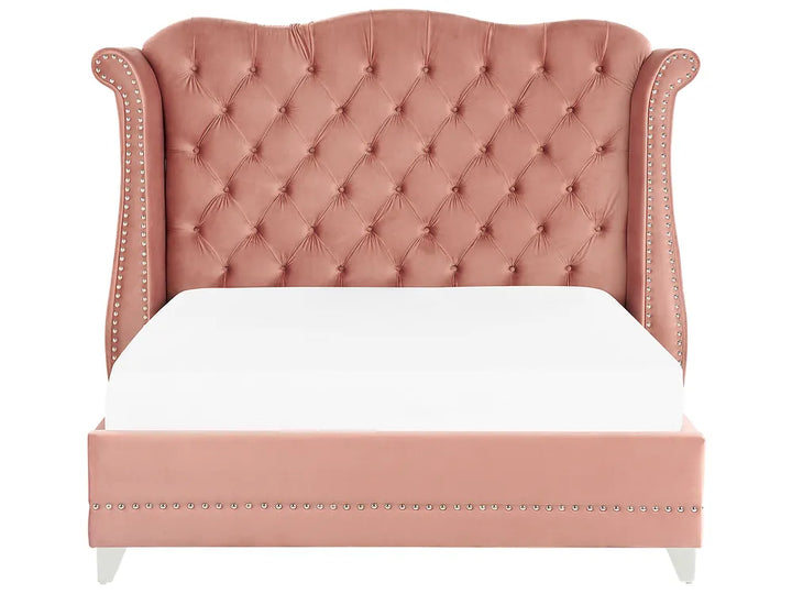Pink tufted bed with white bedding on a white background