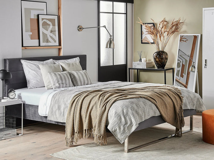 Modern bedroom with a bed, side tables, and decorative elements.