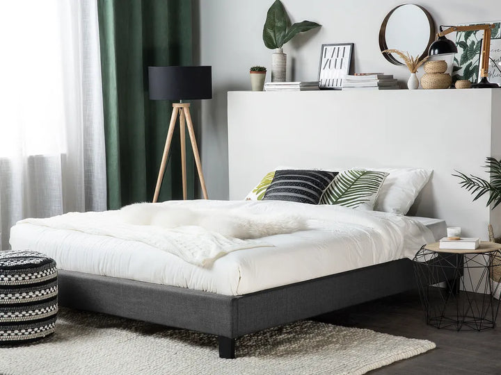 Modern bedroom with a bed, side tables, and decorative items.