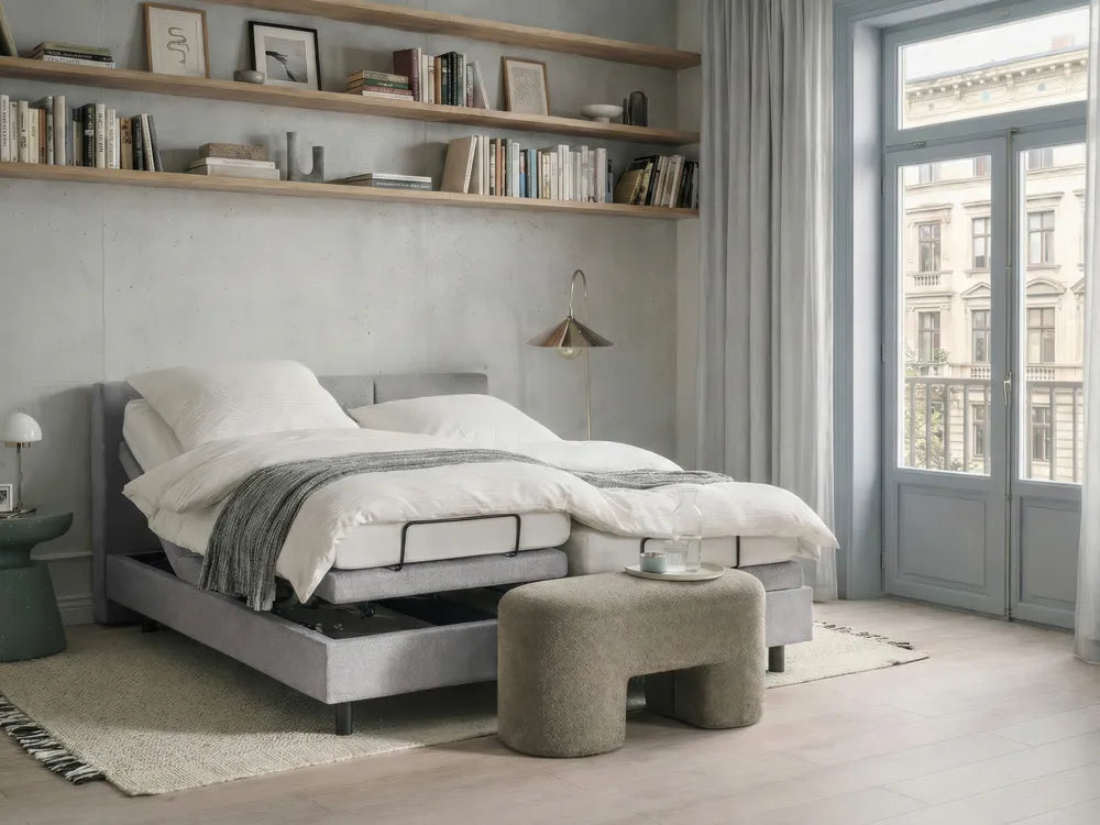 Modern bedroom with a gray bed, ottoman, and bookshelves.