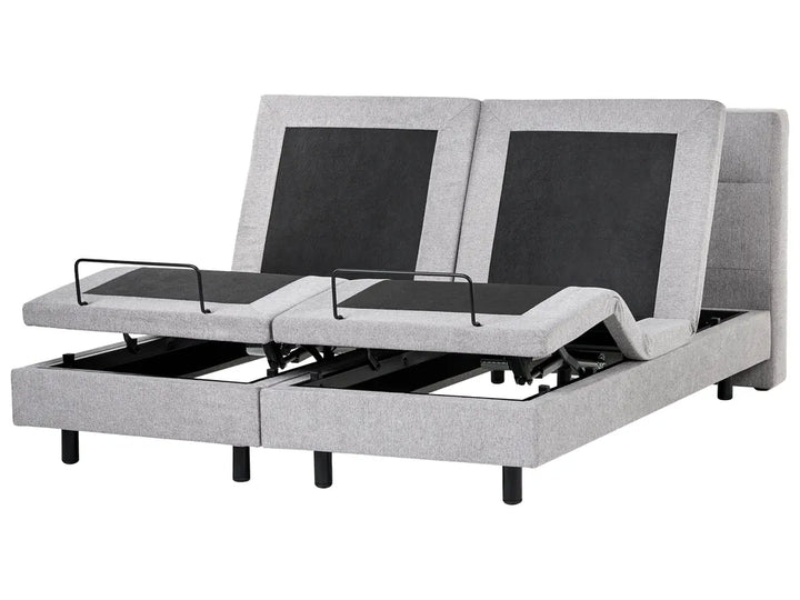 Gray adjustable bed with black control panels on a white background