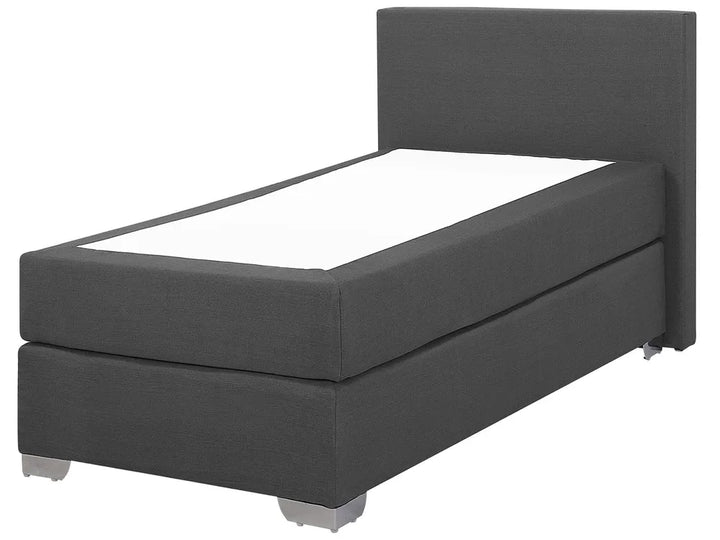 Dark gray upholstered bed with white mattress on a white background