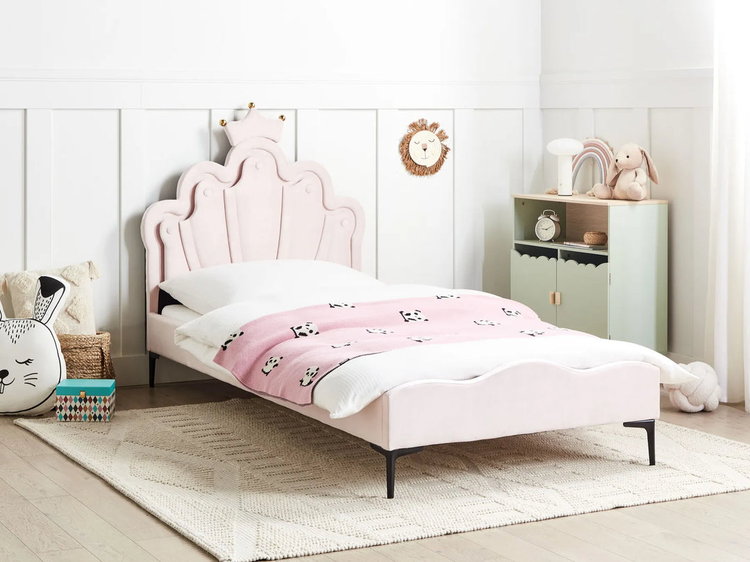 Pink children's bed in a room with a white wall and wooden floor.