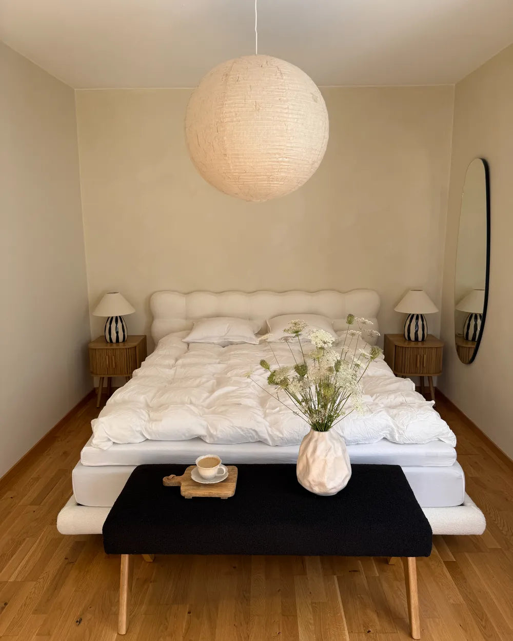 Modern bedroom with a bed, nightstands, and a pendant light.
