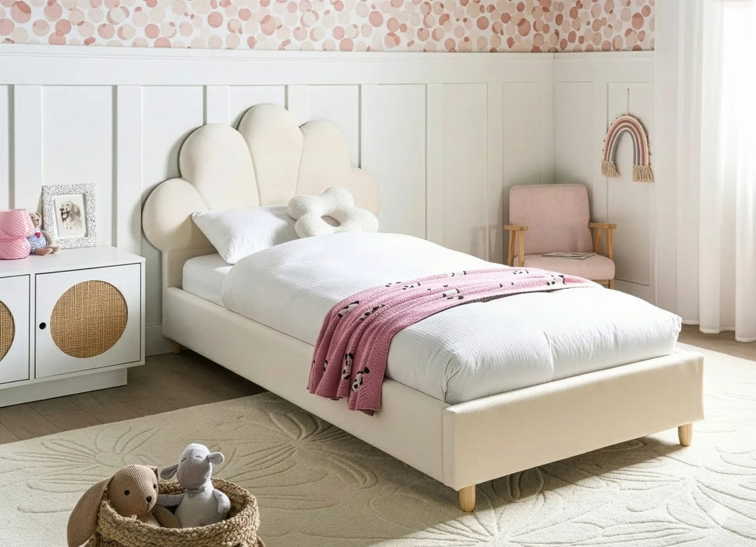 Children's bedroom with a white bed, pink blanket, and toys.