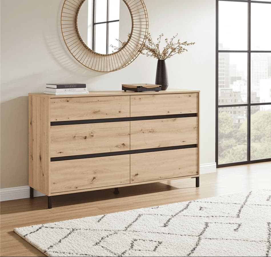 Wooden dresser with black accents in a room with large windows and a round mirror.