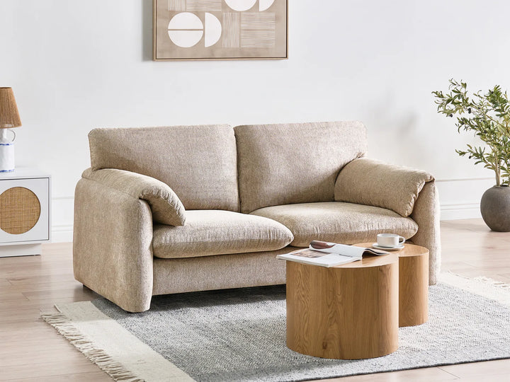 Beige sofa in a living room with a wooden coffee table and decorative items.