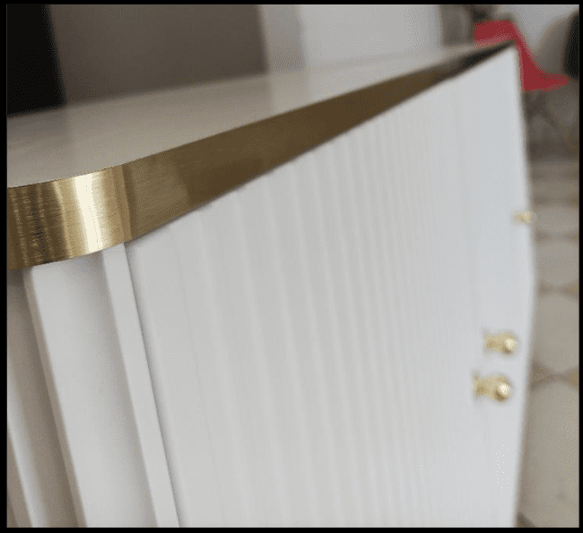 White cabinet with gold trim and handles