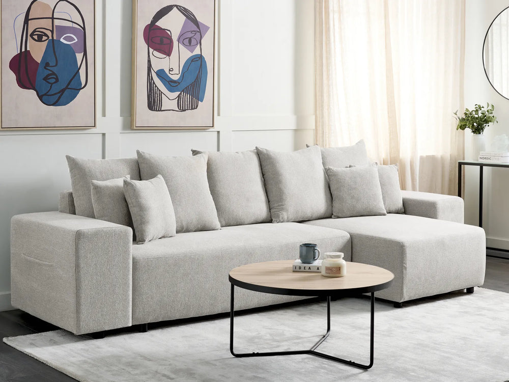 Gray sectional sofa in a living room with abstract art and a coffee table.