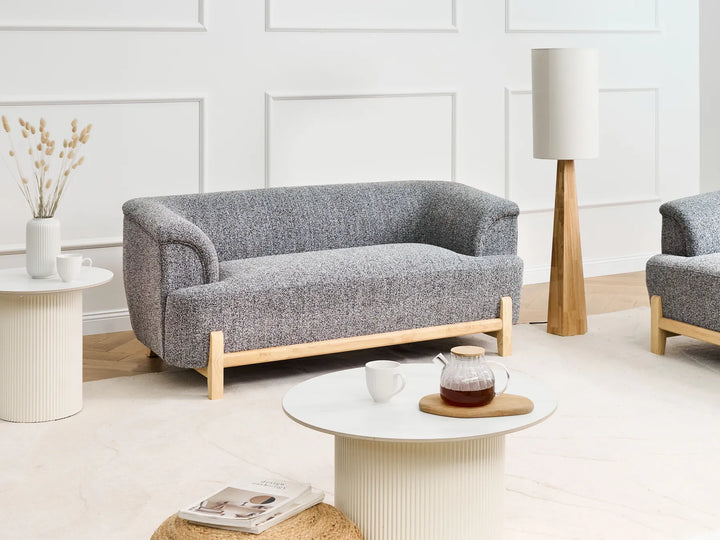 Gray sofa with wooden legs in a modern living room setting.