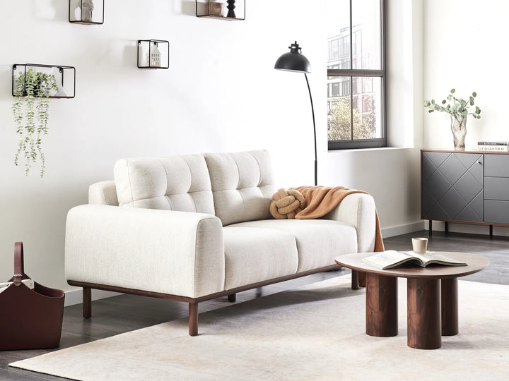 Modern living room with a white sofa, wooden coffee table, and decorative elements.